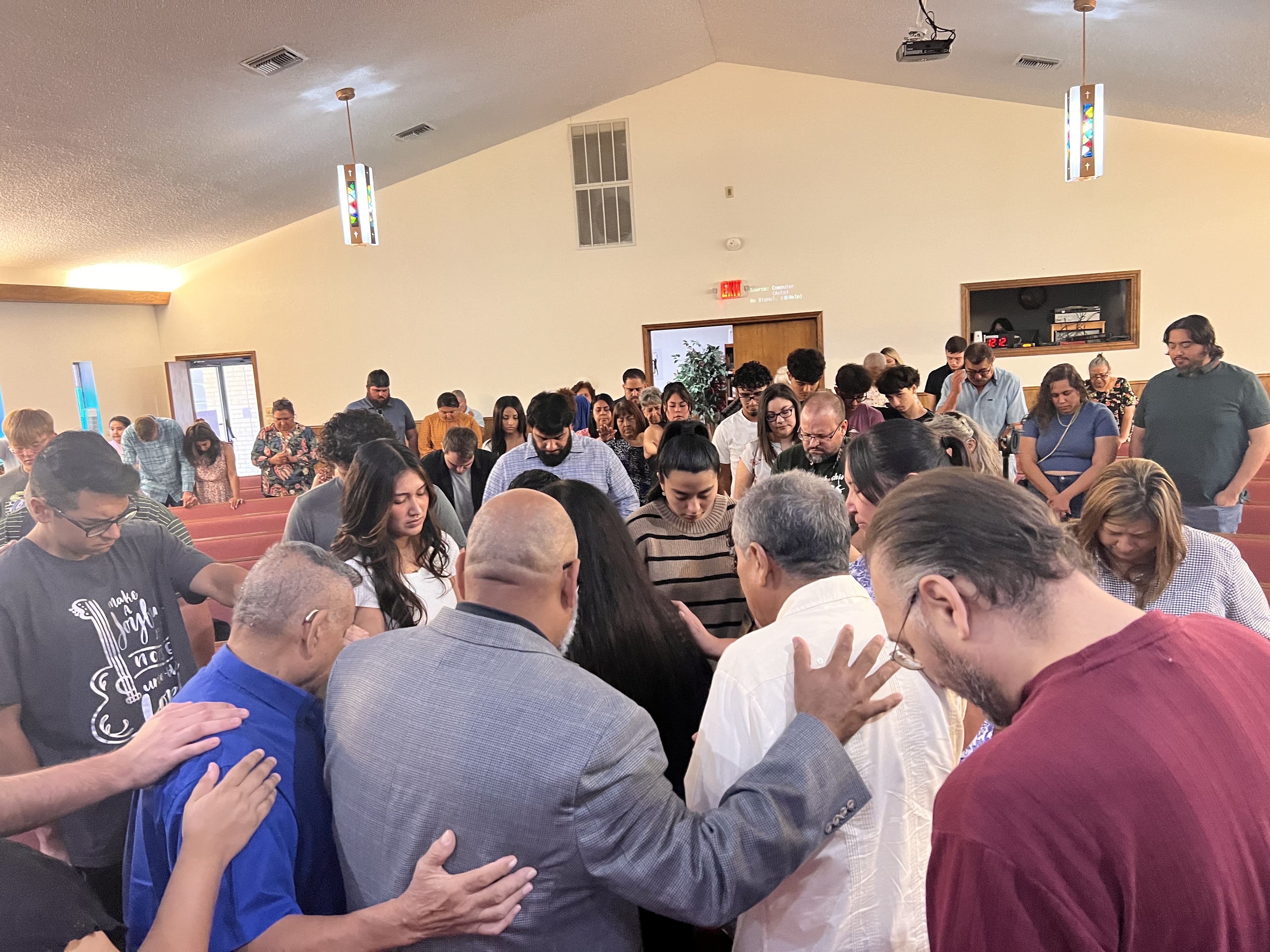 Members of Primera Baptist Church gathered in prayer in the fellowship hall