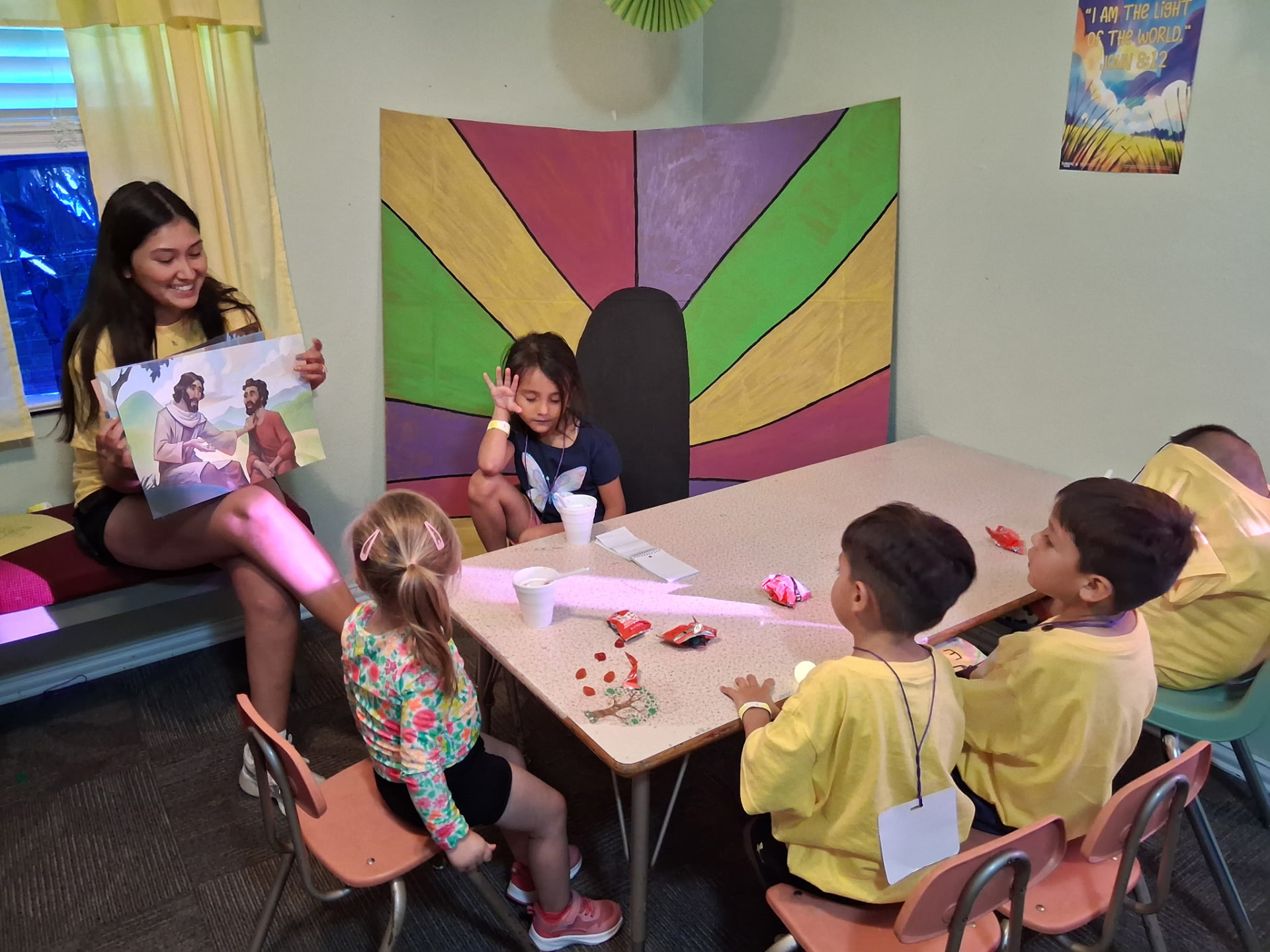 A volunteer teaching a Bible story to young children around a table
