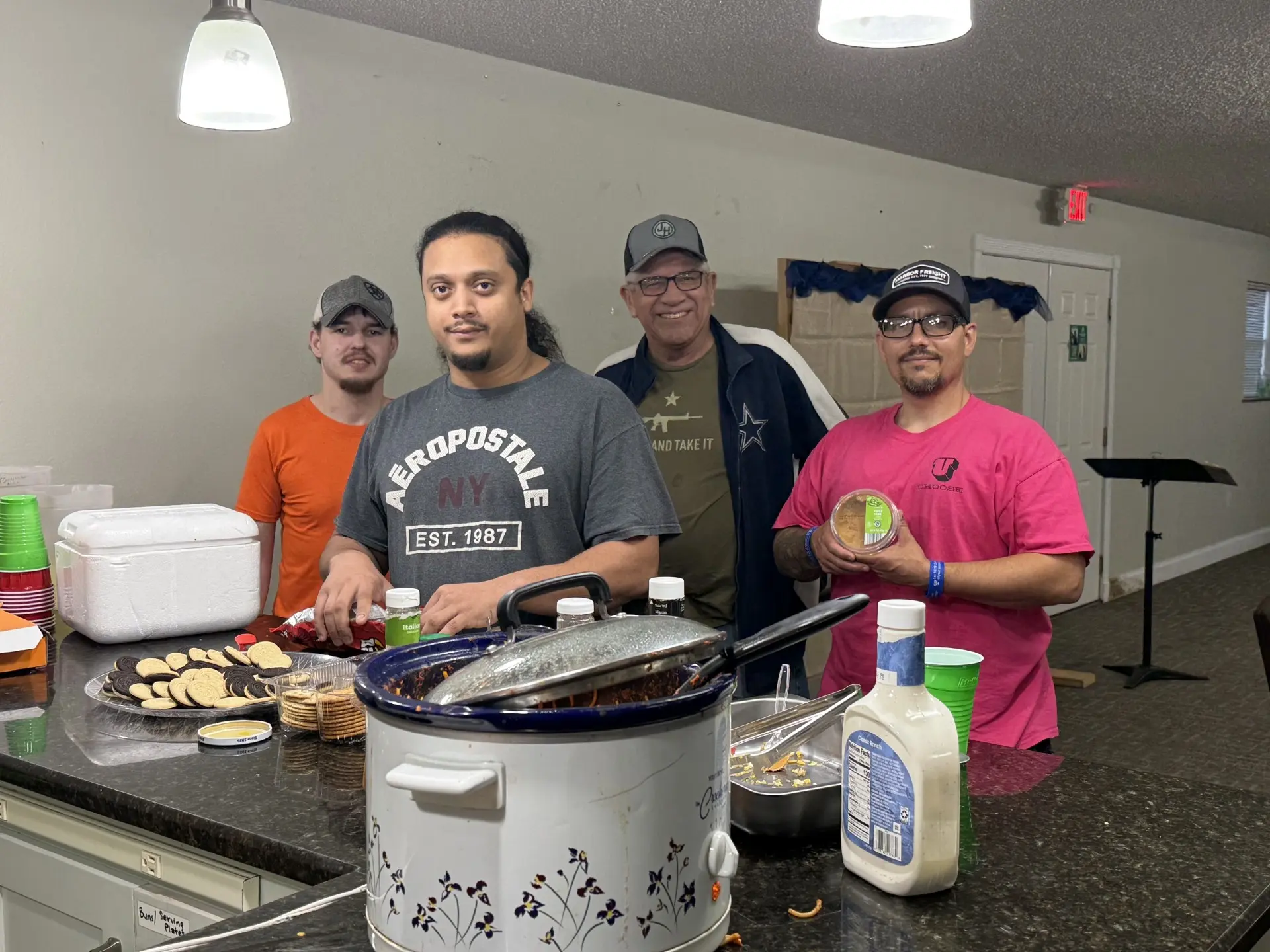 Job Corps men serving chili dogs together in the fellowship hall