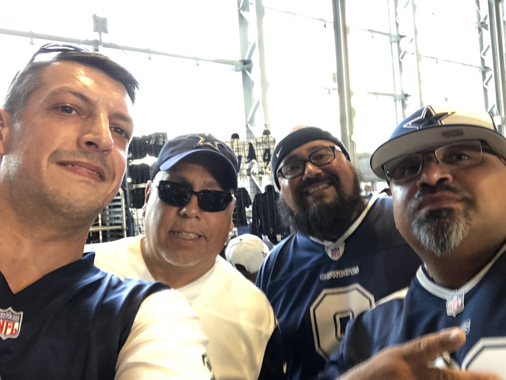 Men's group members taking a selfie together at a Cowboys game
