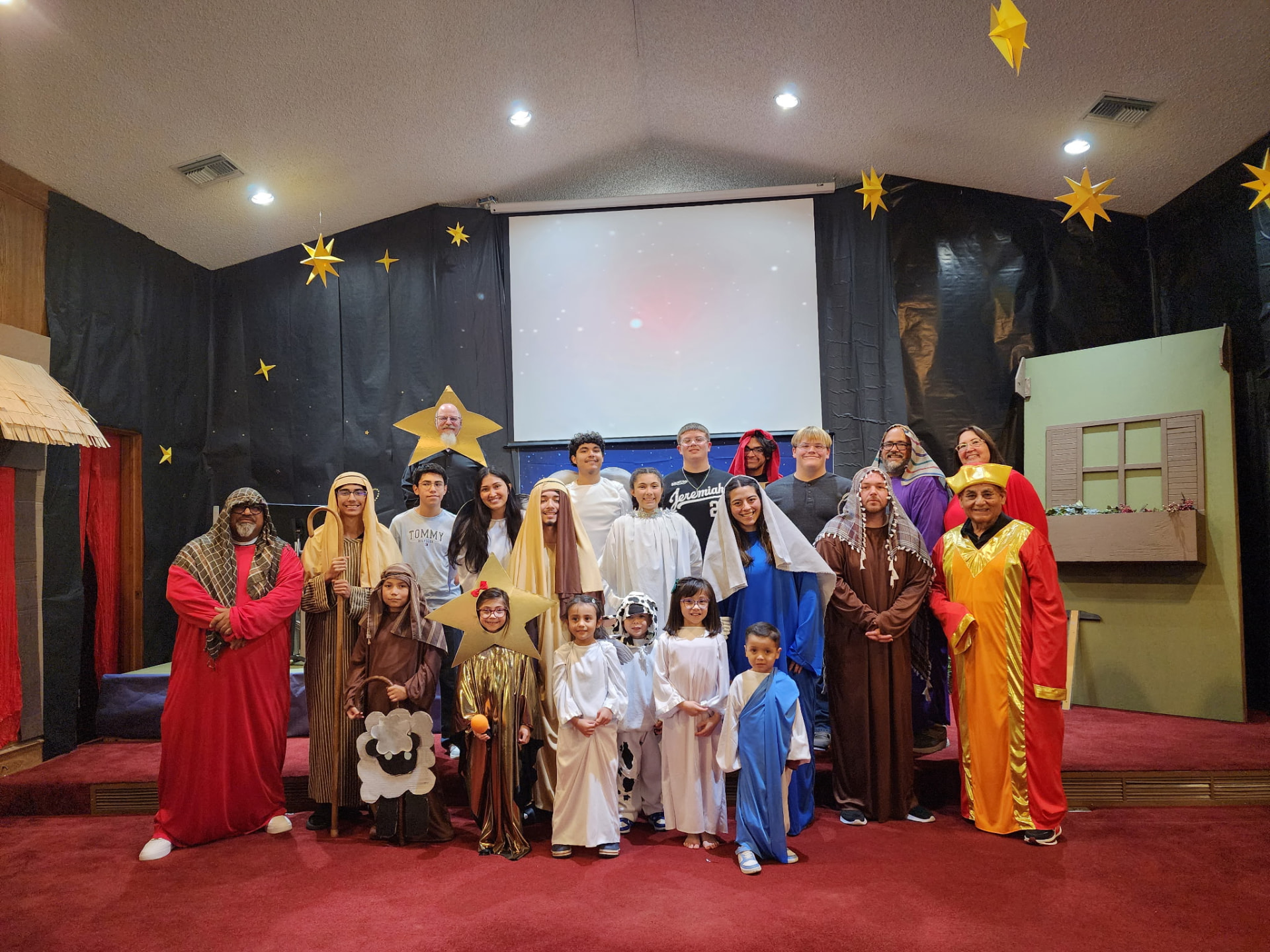 Students and adults in costume on stage after the Christmas nativity program