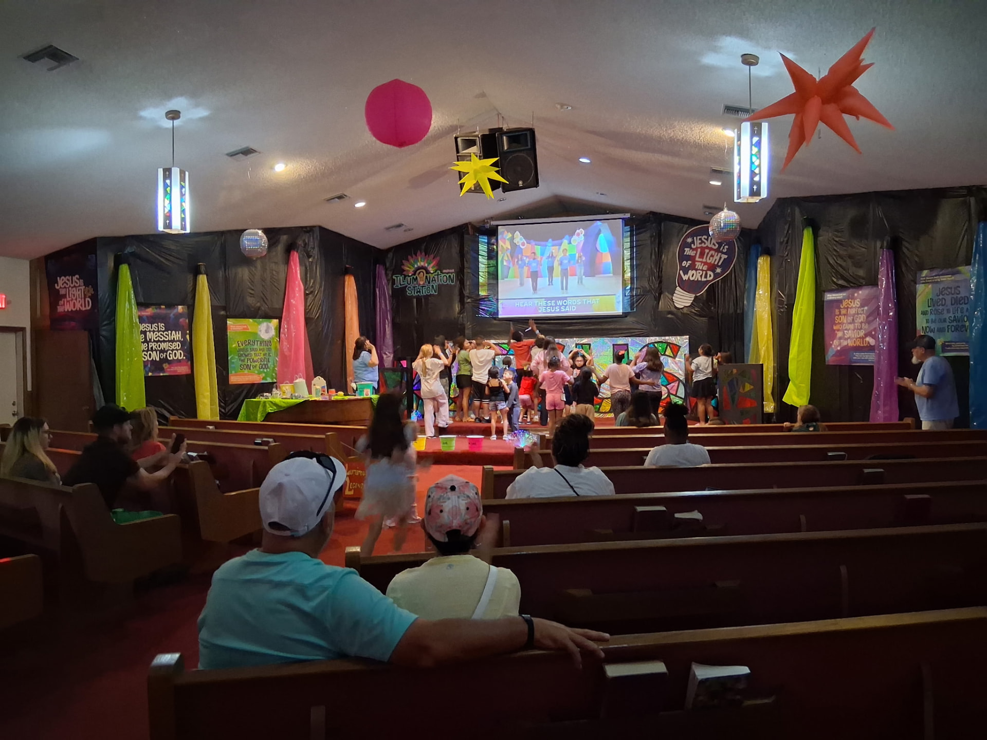 Children singing and dancing at the front of the sanctuary during Vacation Bible School