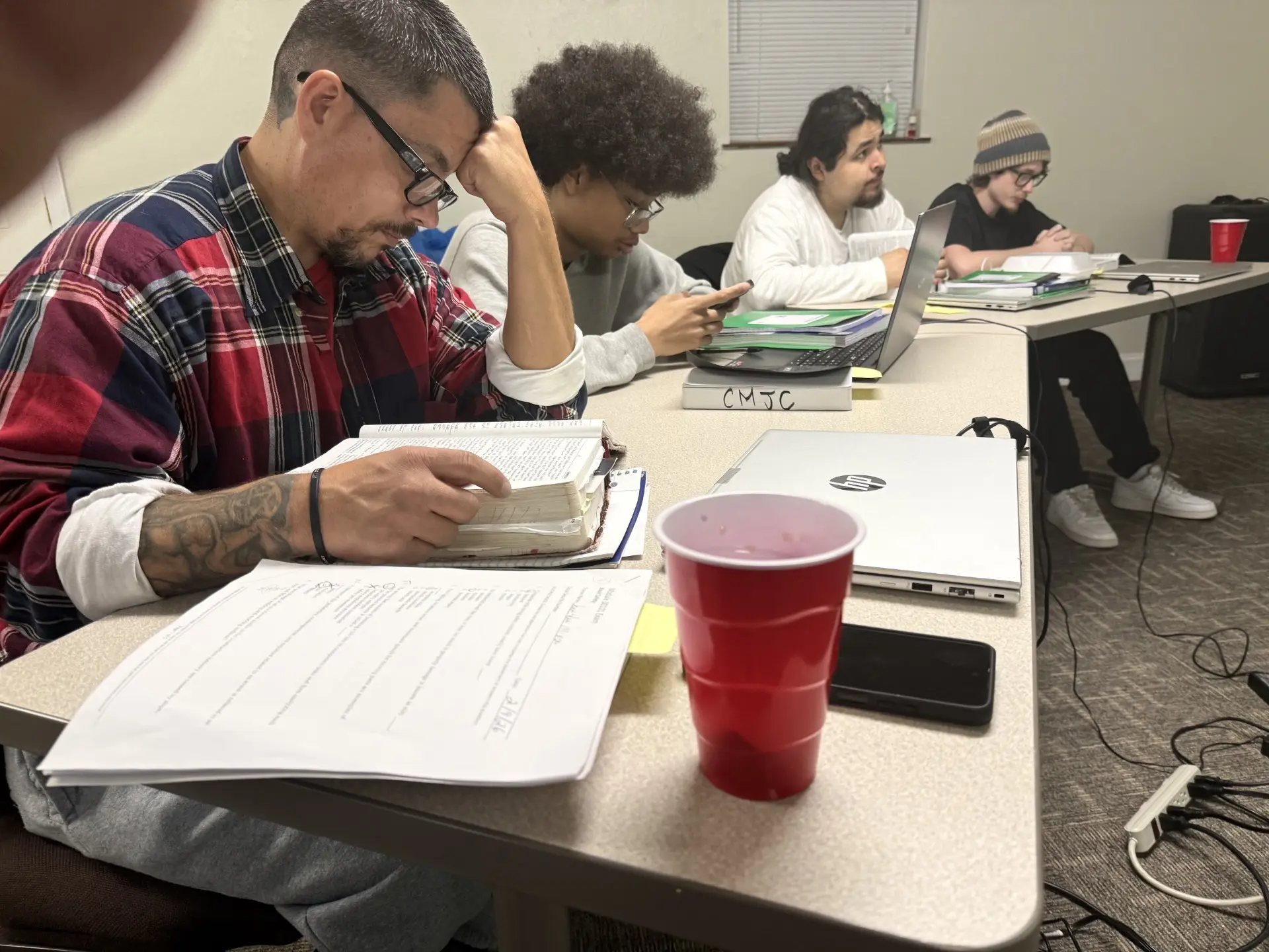 Men studying their Bibles and workbooks in a Job Corps class
