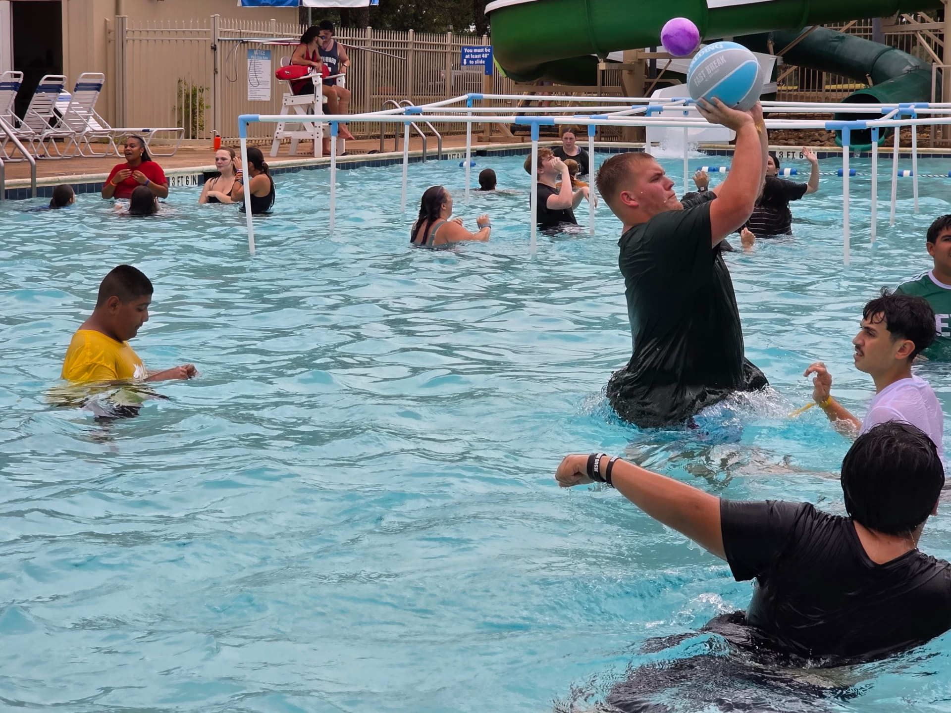 Students and leaders playing pool basketball during camp free time
