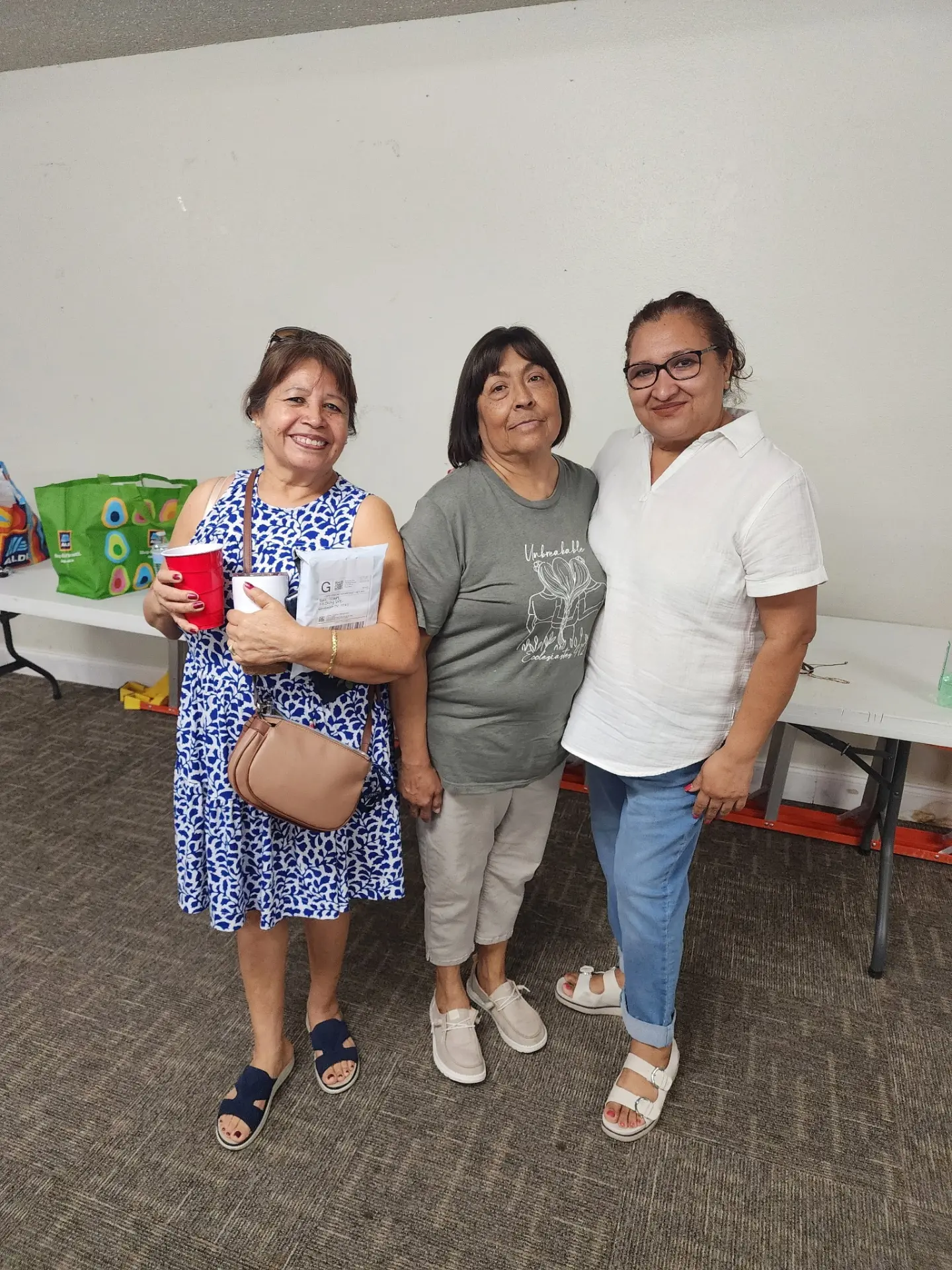 Three women from the church smiling together at a gathering