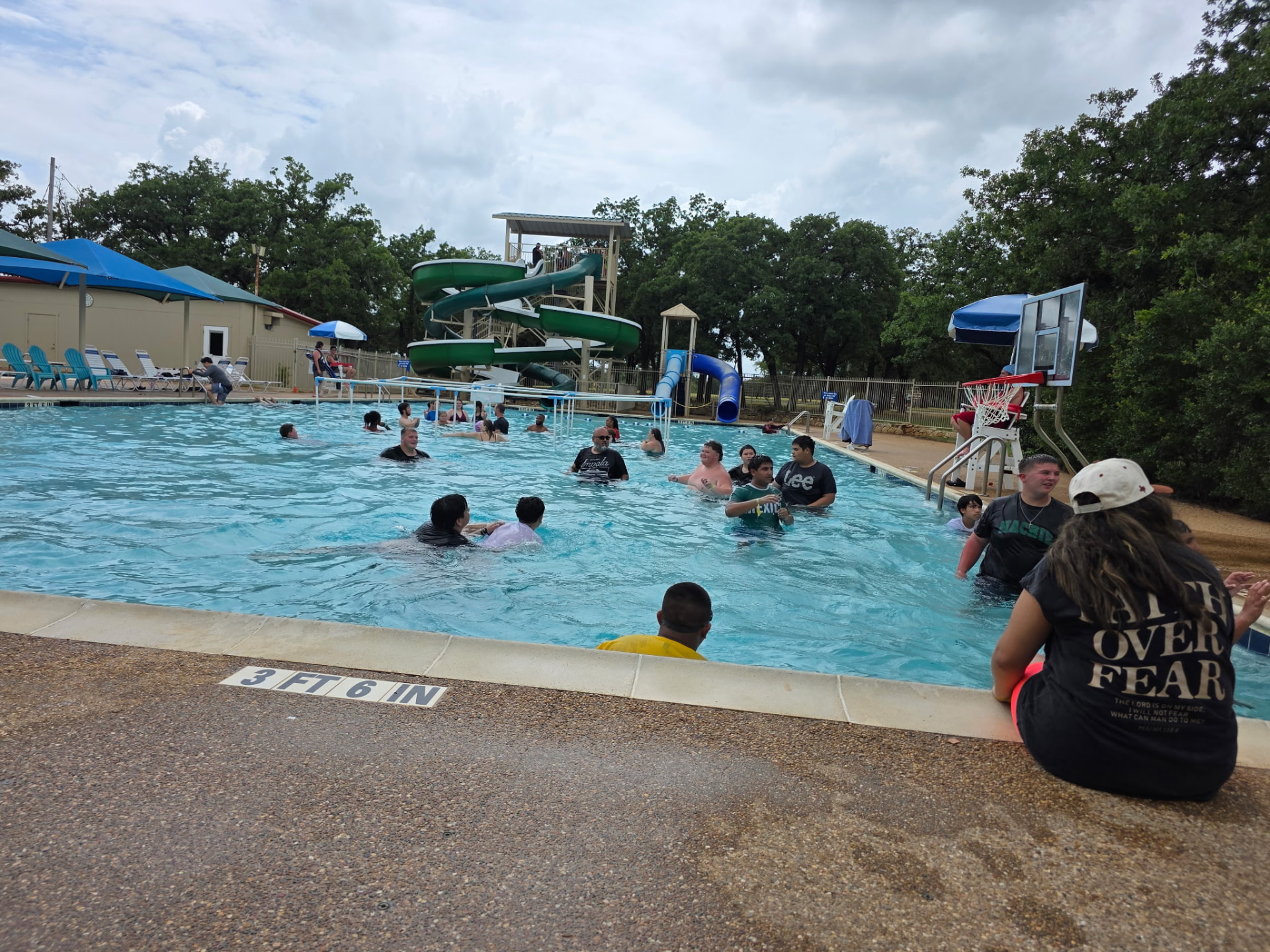 Students cooling off together in the camp pool by the water slides