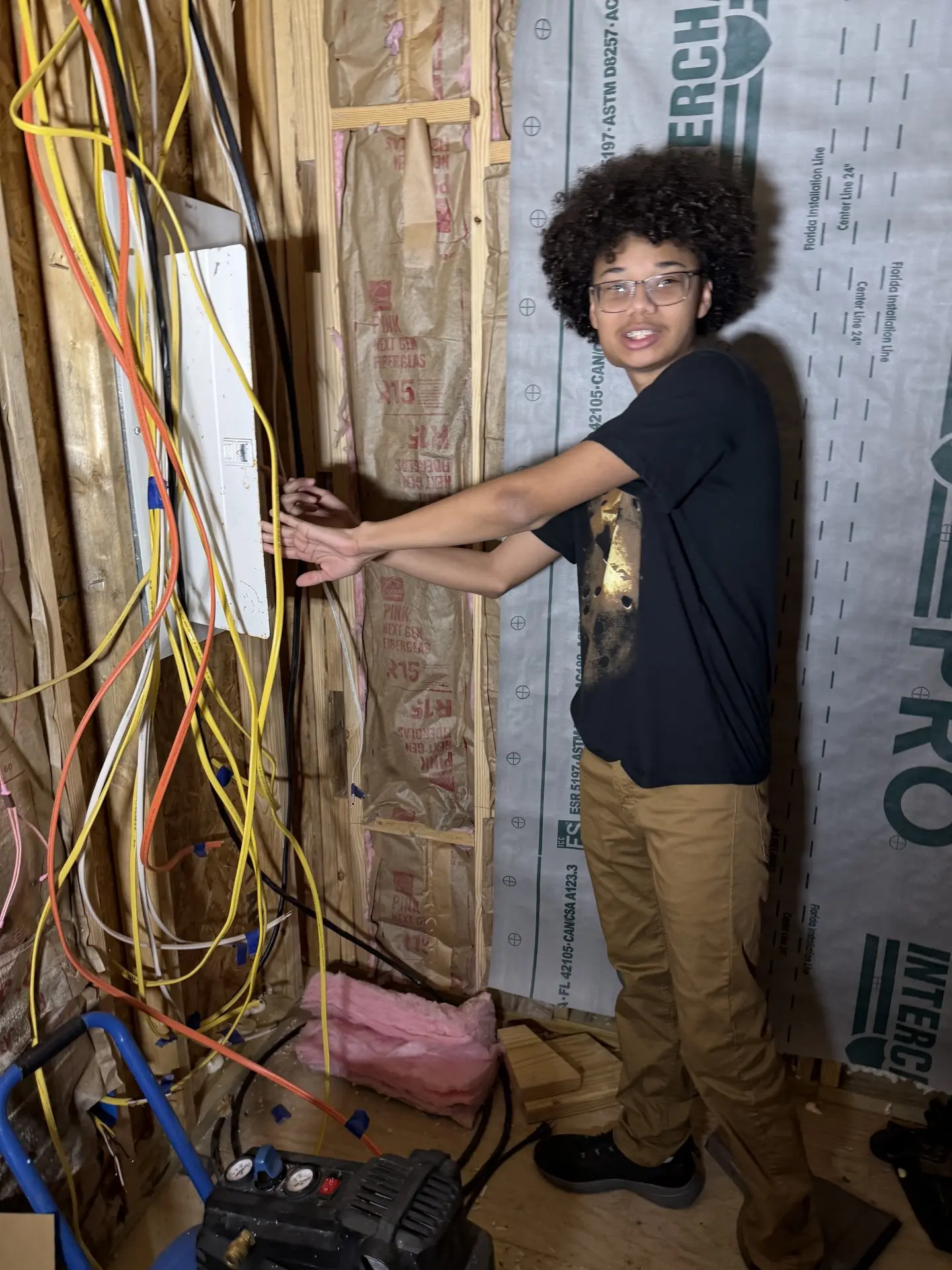 A Job Corps student running electrical wiring on a job site