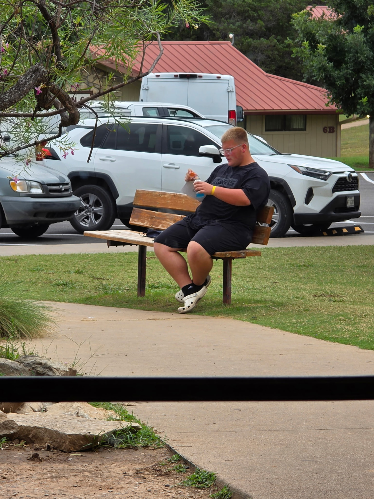 A student taking a break on a bench between camp sessions